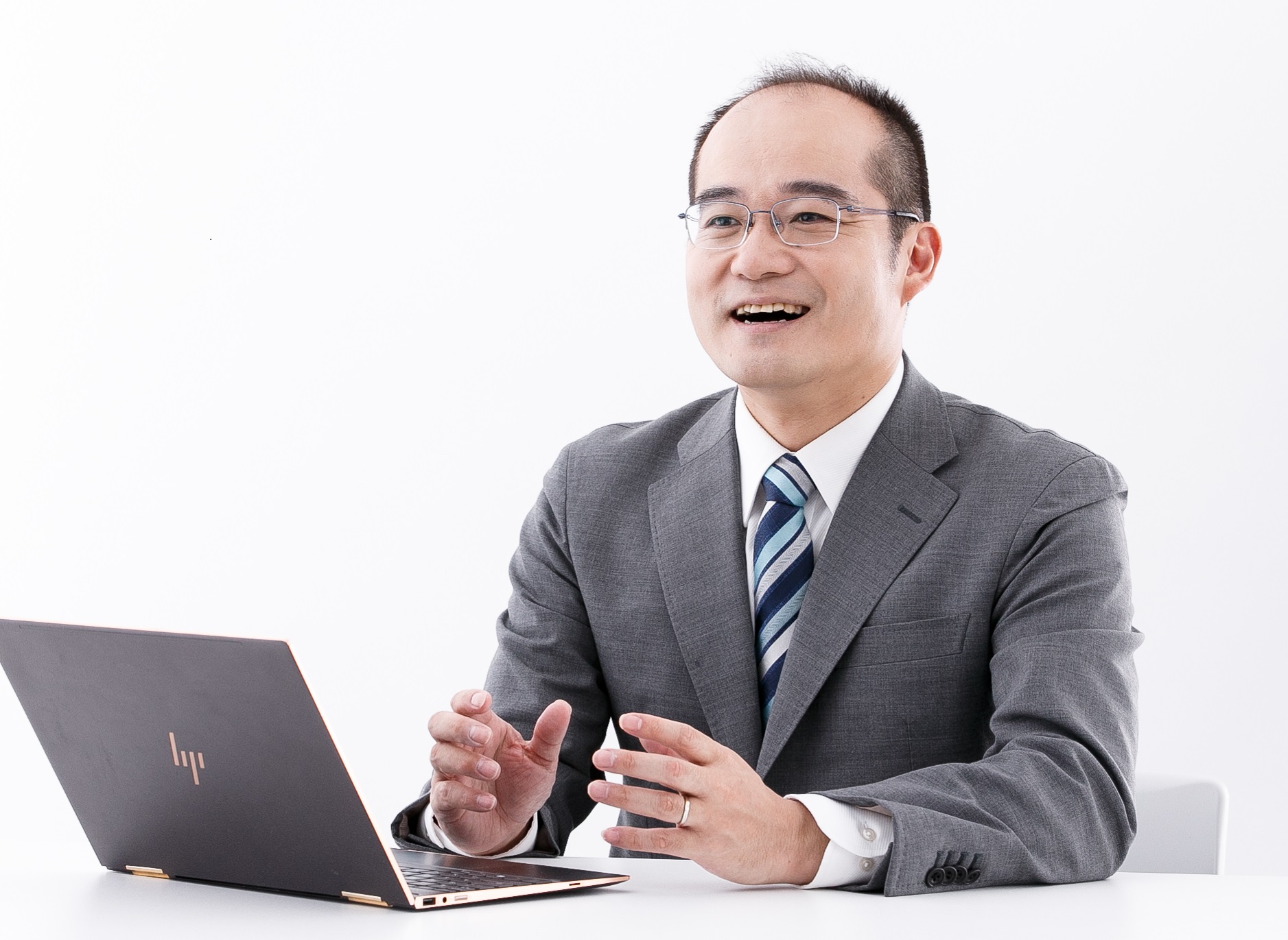 笑顔でノートPCを前に説明する代表 安藤準