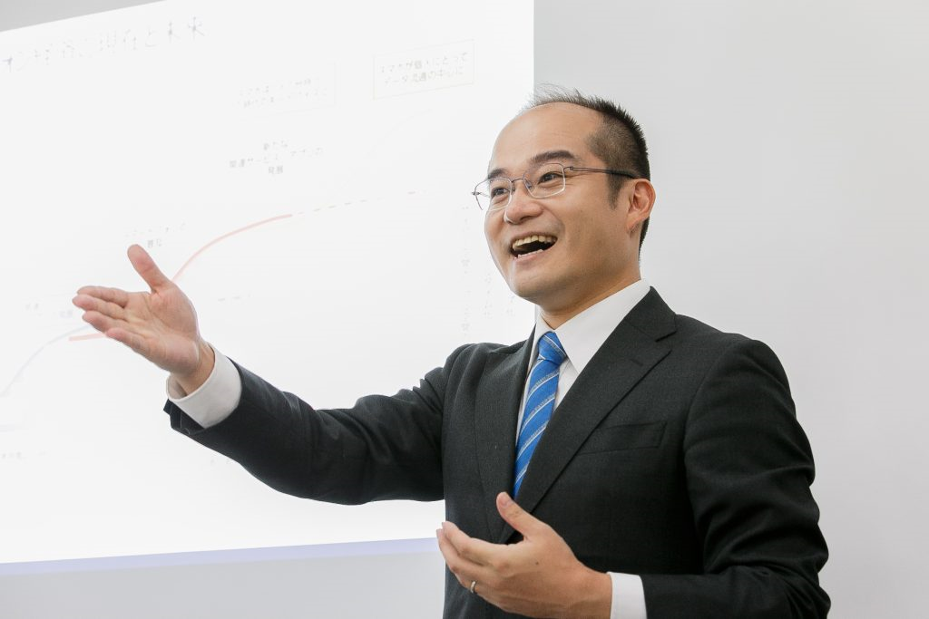 ホワイトボードを使い笑顔で講義する代表 安藤準